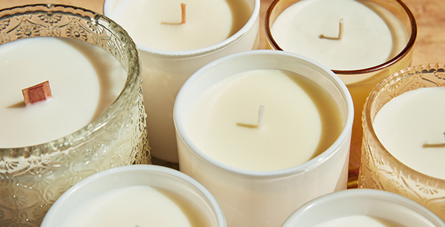 Close-up of white unlit candles in glass jars