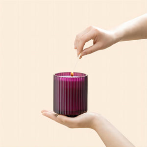 Photo shot of lighting Amélie - Lavender & Lilac 12.3oz candle with a match