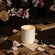Photo shot of a lit Lucienne - Cherry Sakura 8oz candle, surrounded by stacked letters and scattered cherry blossom petals