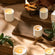 Collection shot of  Lucienne candles in various scents and sizes placed on small wooden boards