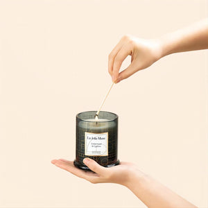Photo shot of lighting Roesia - Cypress and Cedarwood 9.9oz candle with a match