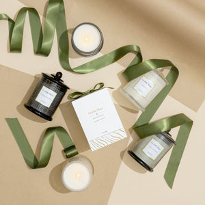 Collection shot of Roesia candles with ribbons and candle packaging