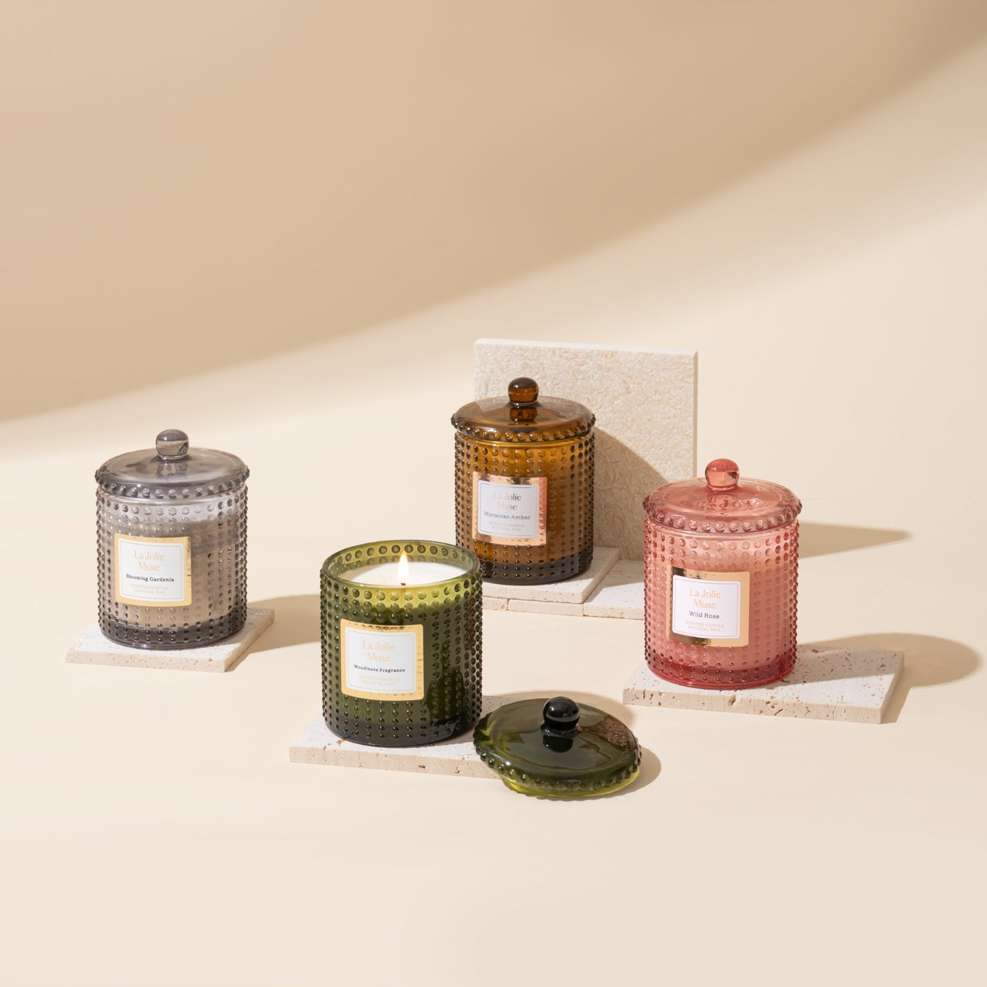Collection shot of Marvella candles with four different scents placed in a scattered arrangement