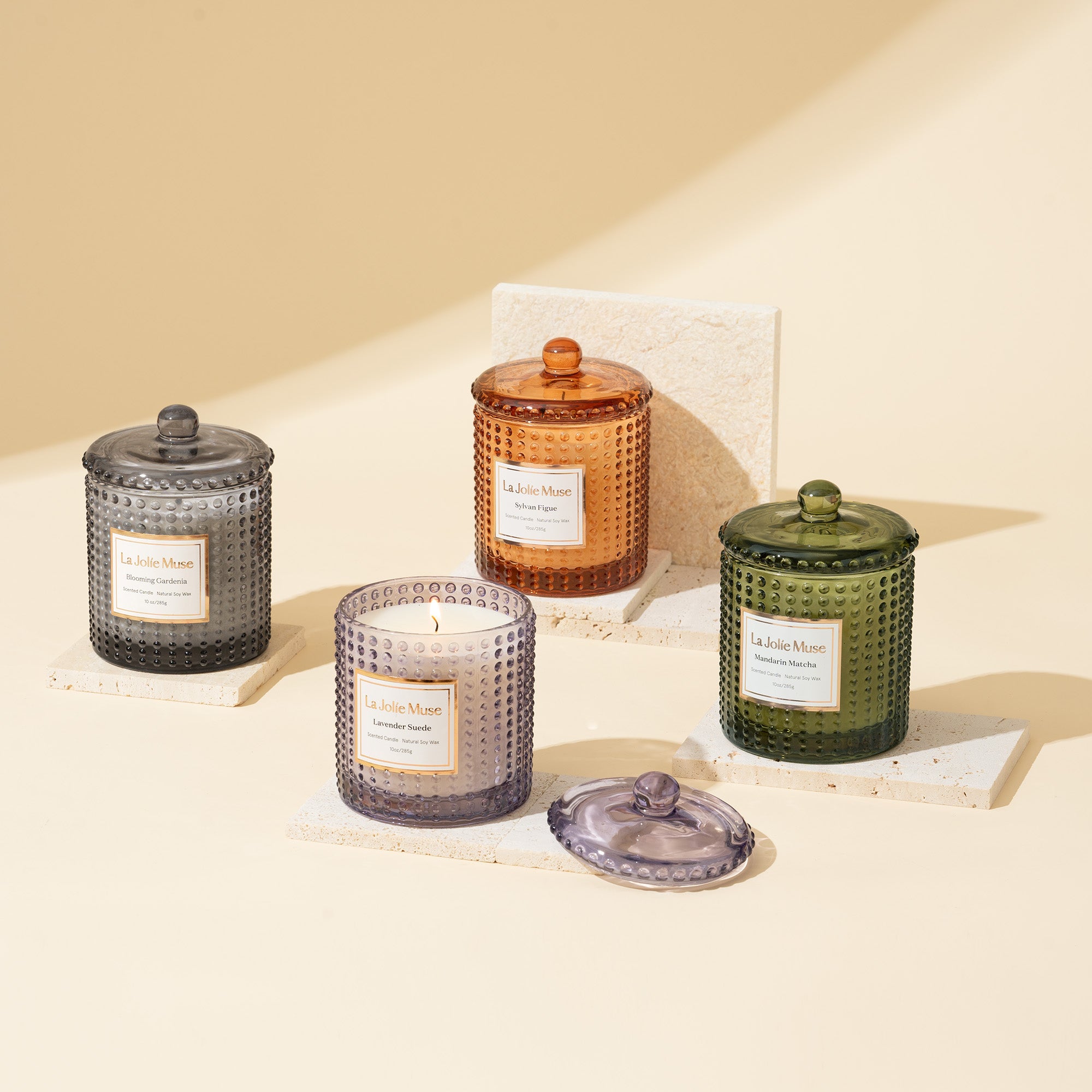 Collection shot of new Marvella candles with four different scents placed in a scattered arrangement