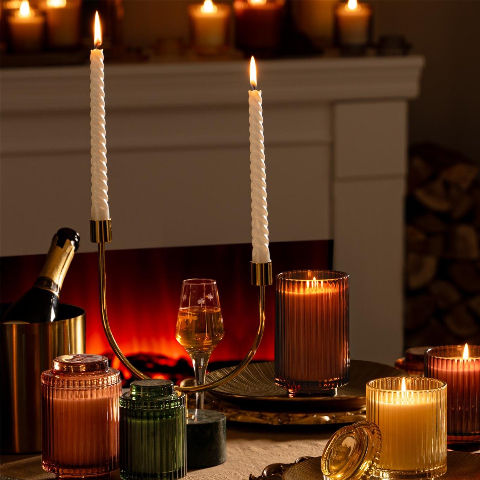 Collection shot of Amélie candles in various scents and sizes with dinner candles lit - view 1