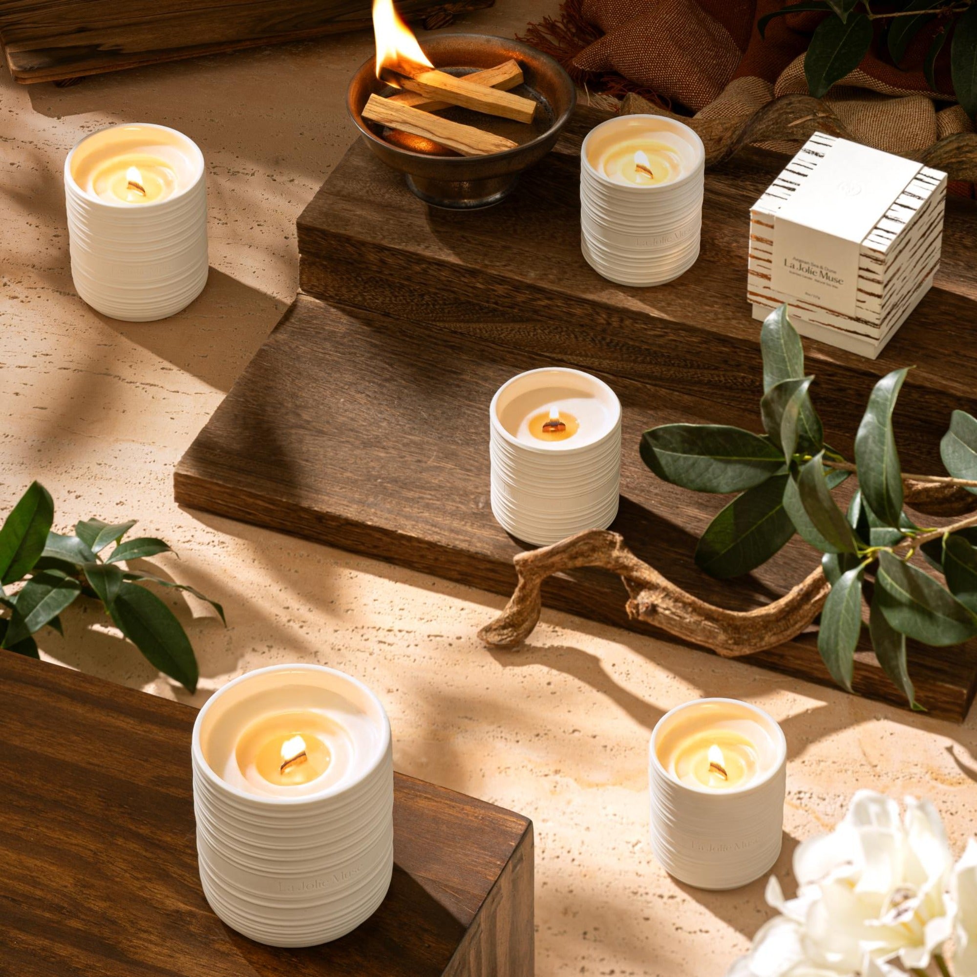 Collection shot of  Lucienne candles in various scents and sizes placed on small wooden boards