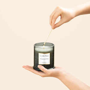 Photo shot of lighting Roesia - Pomegranate & Pine 10oz candle with a match candle with a match