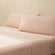 Olivia blush pink linen bed set. Blush pink linen pillows and blush pink linen sheets on bed from side angle.