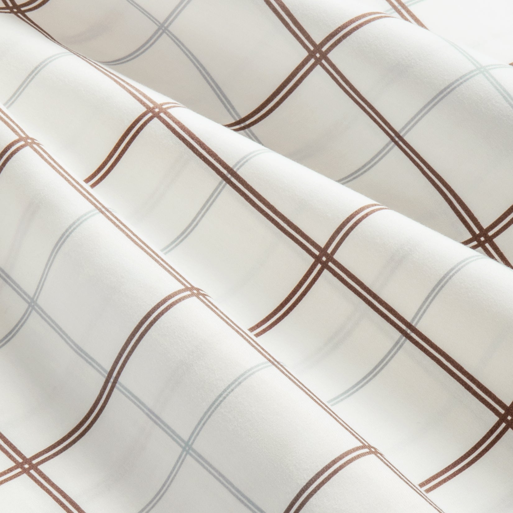 Close up details of Camille Taupe Plaid Pleated Cotton Sheet Set. Cream bedsheet with brown and gray lines close up.