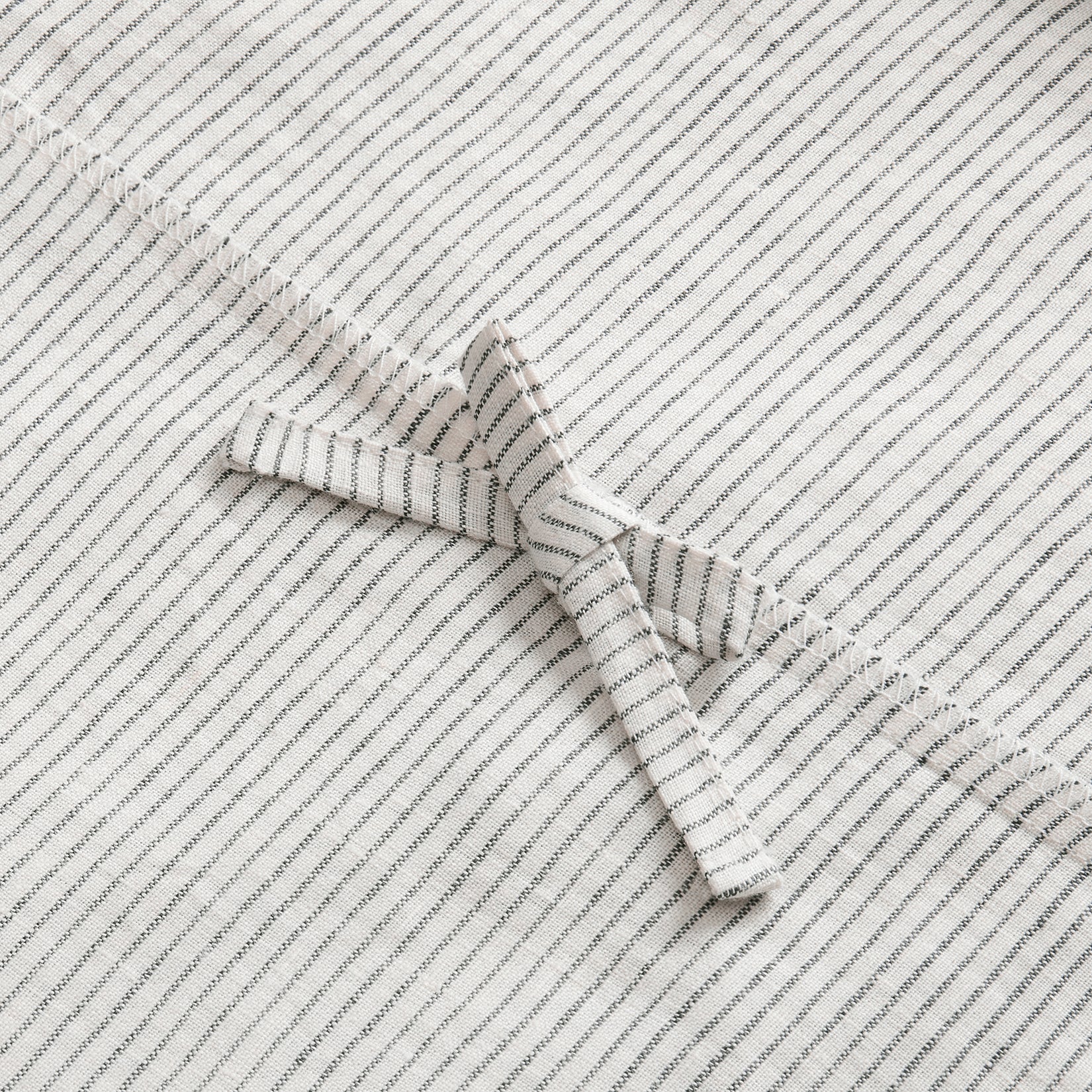 Close up details of Olivia black and white stripe linen duvet set. Black and white striped linen duvet set close up of corner tie.