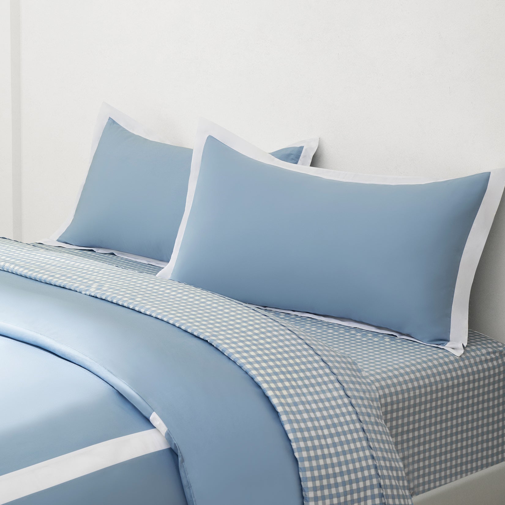 Paulina Sky Blue 200 thread count combed cotton duvet set. Sky blue and white pillows and sky blue and white sheets on gingham bed sheets.