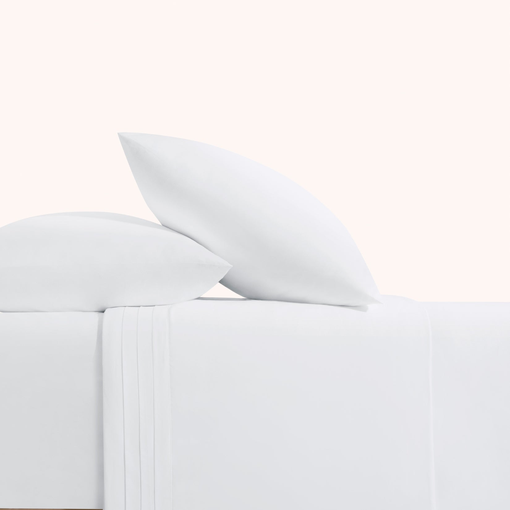 Camille Classic White Pleated set. White pillows on white duvet from side view. 