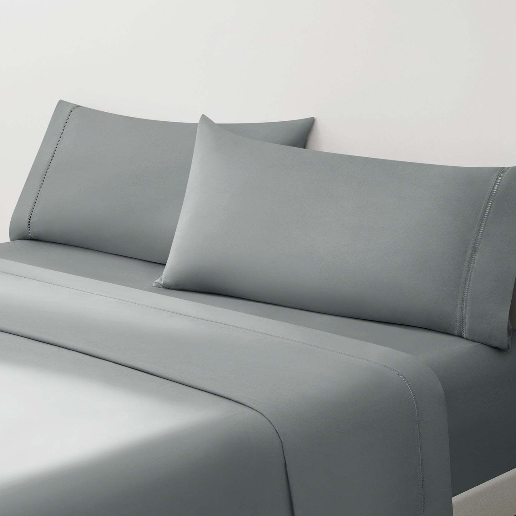 Camille Mid Gray bed set. Dark gray pillows and dark gray sheets on bed from side angle.