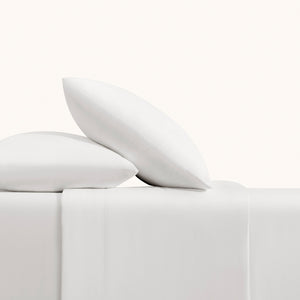 Olivia soft white linen sheet set. Soft white pillows and natural taupe sheets on bed from side view.