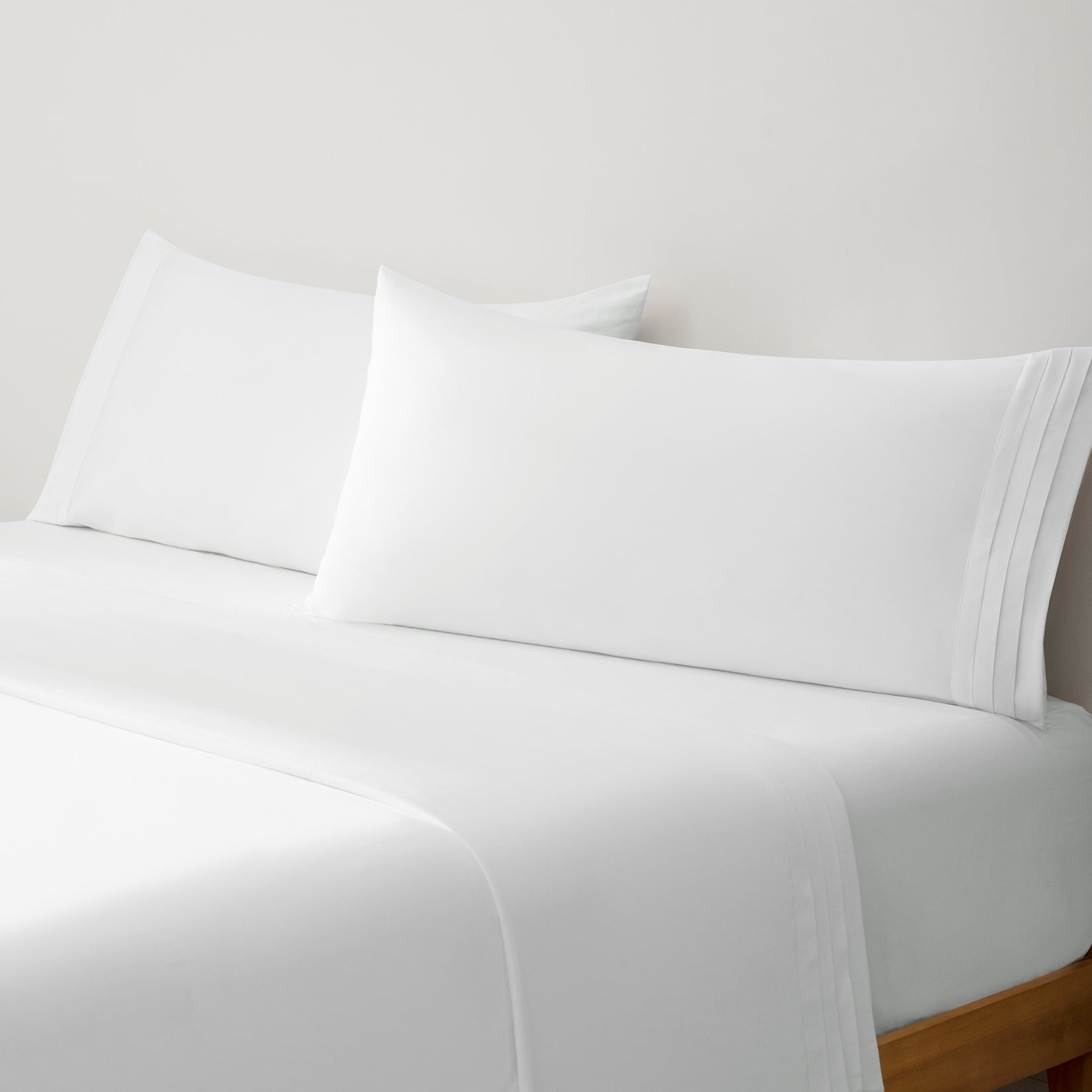 Camille Classic White Pleated set. White pillows on white duvet from side view. 