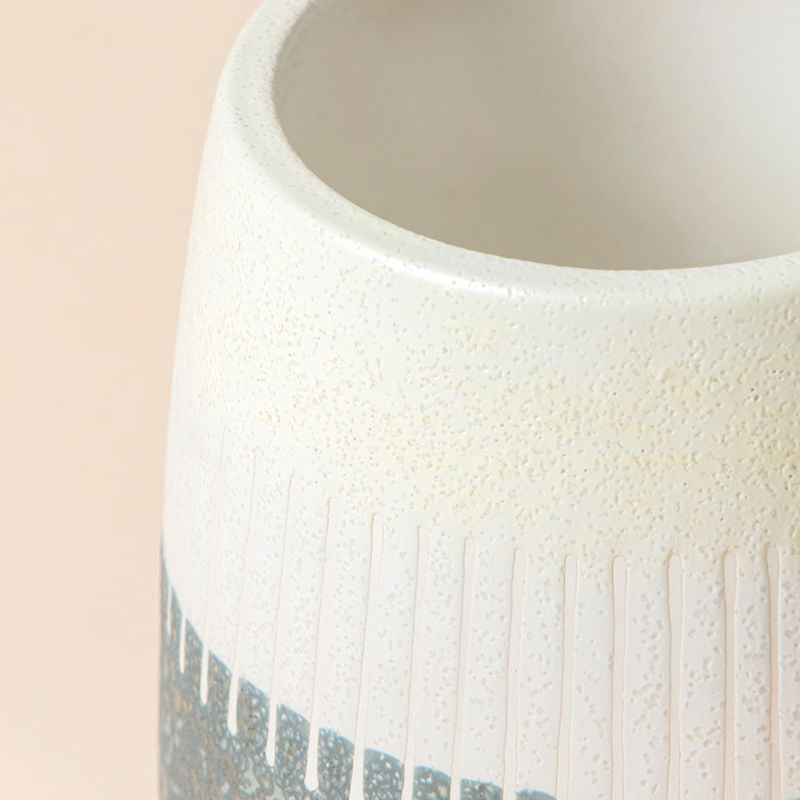A close-up of the 5.1-inch gray and ivory ceramic pot, showing its lines pattern, and color design.