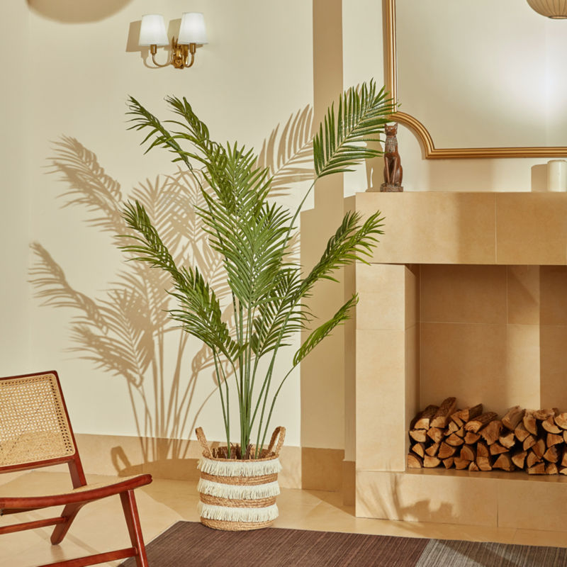 In the picture, a artificial palm tree is place near a fireplace and a chair, and its height is 5.9 feet.