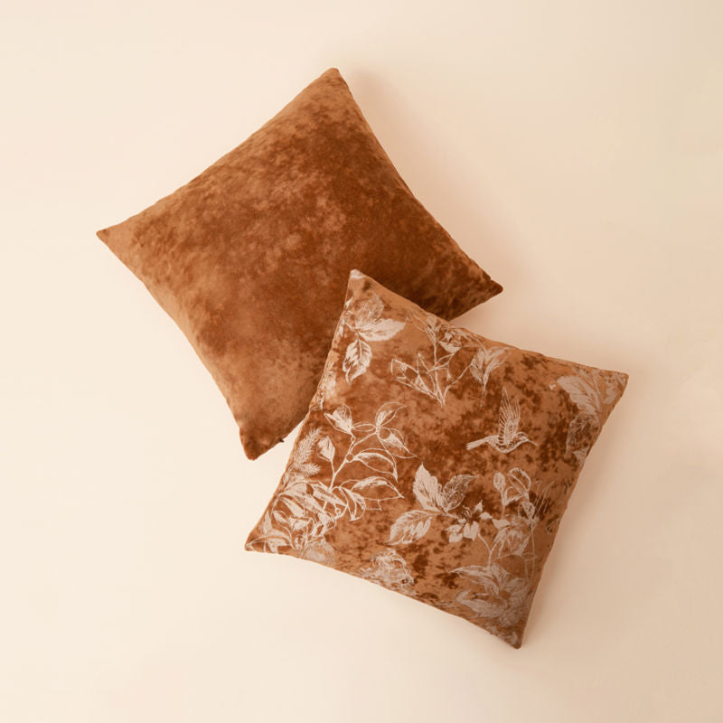 A pair of pillows in 18 *18 Belinda caramel brown floral pattern velvet pillow cover is posted in a staggered position.