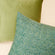 A group of two pillows in Bena fir green pillow cover is displayed, one showing the front, the other showing the back.