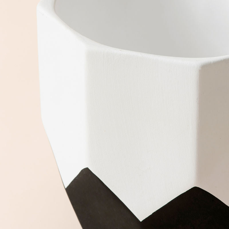 A close-up of the small pot in the set. Showing its classic black and white palette and modern geometric pattern at the bottom.