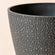 A close up of charcoal black planter, showing its stone textured exterior and dimension in 9.4 inches.