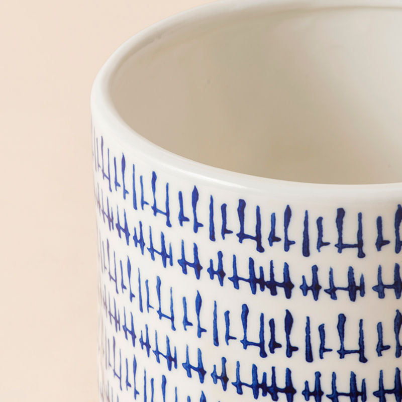 A close up of China blue ceramic planter, showing its delicately carefree cross-hatching designed to mimic brush strokes.