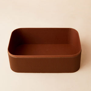 A close up of chocolate brown storage basket, showing its lined interior space.