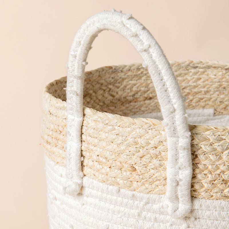 A close-up of the cotton and corn skin laundry basket, showing its traditional corn skin twine and cotton handle.