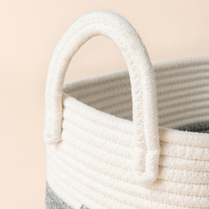 A close-up of cotton rope storage basket, showing its coiled pattern and cotton handle features.
