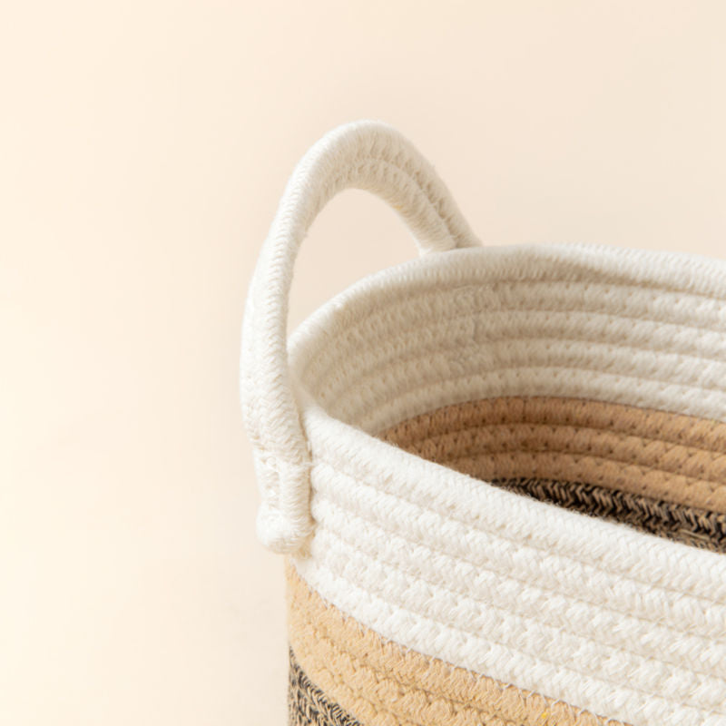 A close-up of cotton rope storage basket, showing its trio color mixed woven pattern and handle features.
