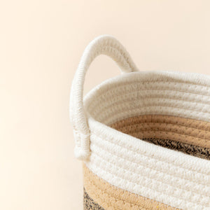 A close-up of cotton rope storage basket, showing its trio color mixed woven pattern and handle features.