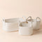 The set of three white baskets are placed in a staggered way. All baskets are made of pure cotton ropes.
