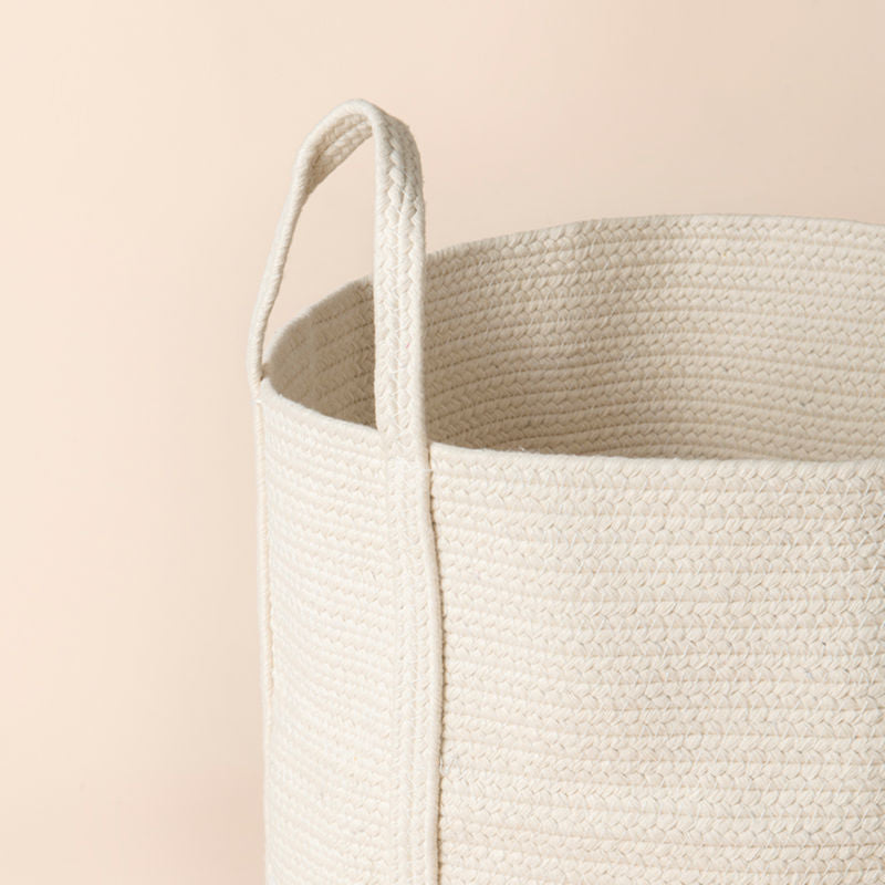 A close-up of white-yellow cotton rope hamper, showing its natural and soft cotton woven pattern.