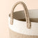 A close-up of the cotton rope laundry basket, showing its beige handle and coiled cotton woven features.