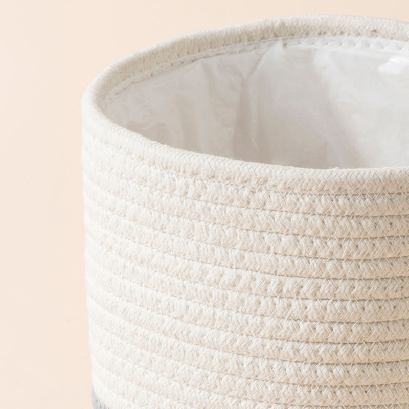 A close up of a smaller white and gray color planter with textured exterior and soft interior created with natural cotton.