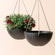A set of two matte black hanging pots with cube pattern, made from recyclable plastic and stone powders.