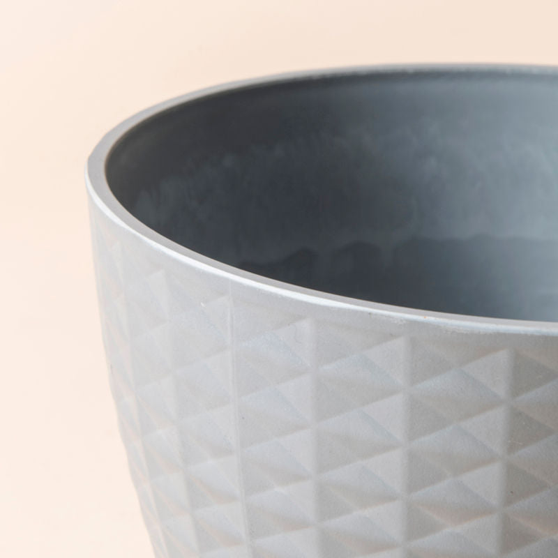 A close up of dawn gray planter, showing the imbricated geometric pattern on its exterior.