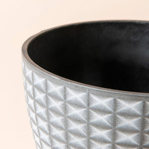 A close up of gray gradient planter, showing the imbricated geometric pattern around its exterior.