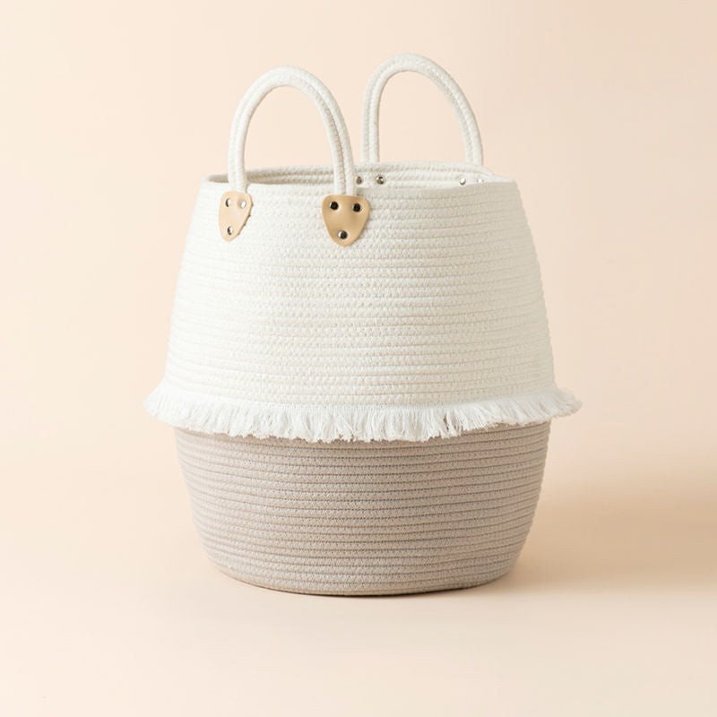 A unique bulging designed cotton rope laundry basket, decorated with white tassels.