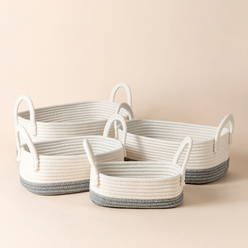 A set of four white and gray cotton rope baskets in different sizes. 