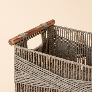 A close up of gray paper rope basket, showing its dowel-style handles and woven pattern.