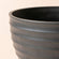 A close up of Greece black planter, showing the elegant curves around its smooth exterior.