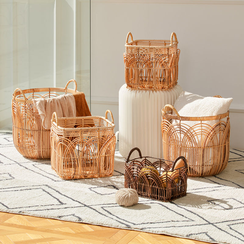 Four baskets in different sizes are staggered on the white carpet, while one basket is placed on a white decorative table.