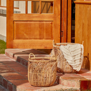 Two handwoven baskets are placed on the steps in front of the door, one of which holds a white blanket.  
