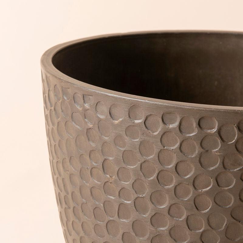 A close up of brown plastic planter, showing the unique honeycomb pattern on its exterior.