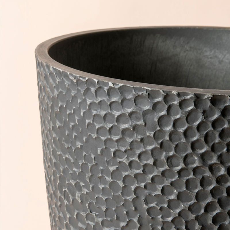 A close-up of the planter, showing its special honeycomb pattern design and its plastic feature.