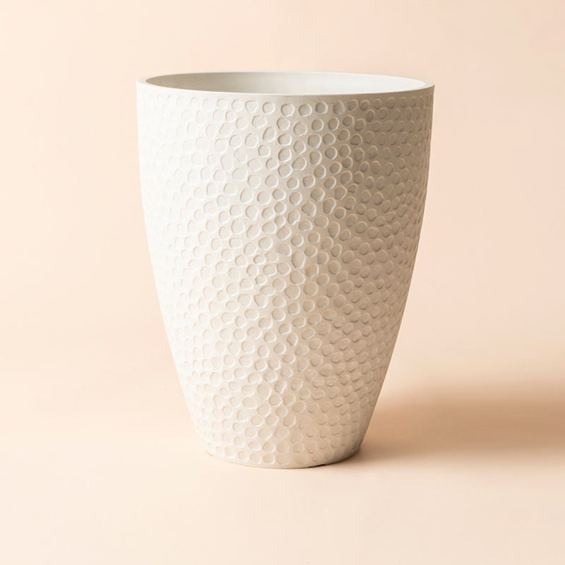 A full view of white tall planter with honeycomb pattern, made from recyclable plastic and stone powders.