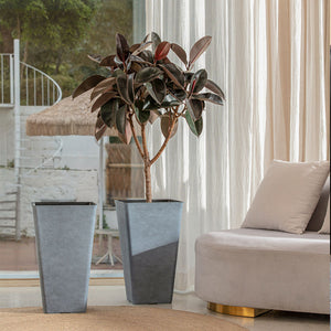 A set of two gray planters in 20-inch one of which holds plants. Pots are displayed in front of a window.
