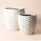 A set of two sand beige pots with lips pattern, made from recyclable plastic and stone powders.