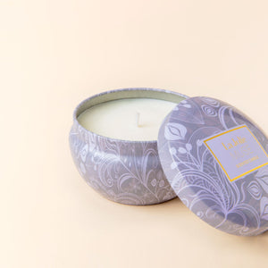 A close up of blue lotus and tulip scented candle, showing its white wax and cotton wick.